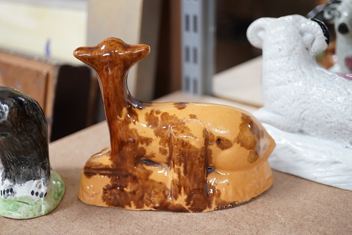 A Staffordshire Pearlware figure of a recumbent ewe, a Staffordshire glazed terracotta figure of a recumbent deer and a Staffordshire pearlware model of a badger?, largest 14cm wide